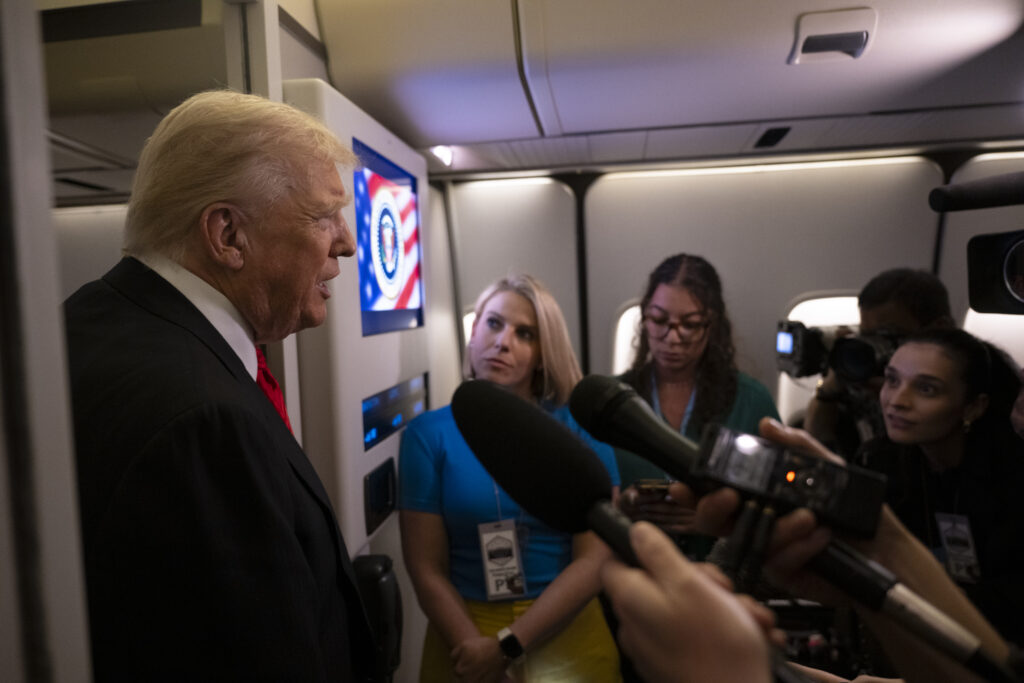President Donald Trump speaks to the press aboard Air Force One