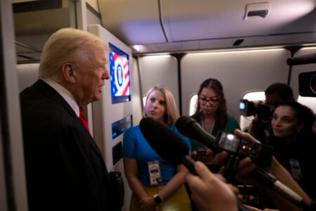 President Donald Trump speaks to the press aboard Air Force One